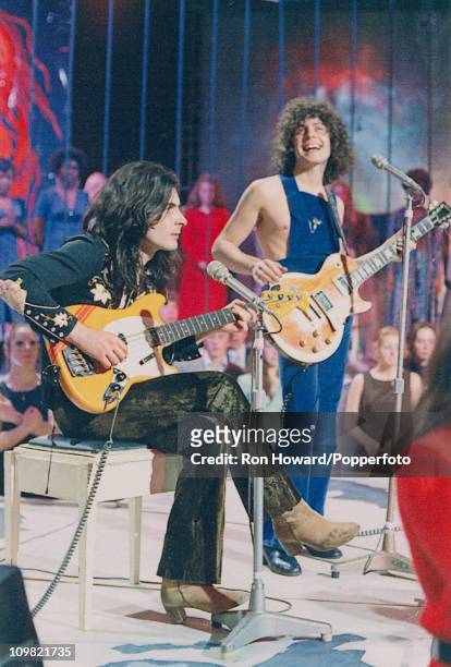 From left, Mickey Finn and Marc Bolan of British pop group T. Rex perform on the set of a pop music television show in London circa 1971.