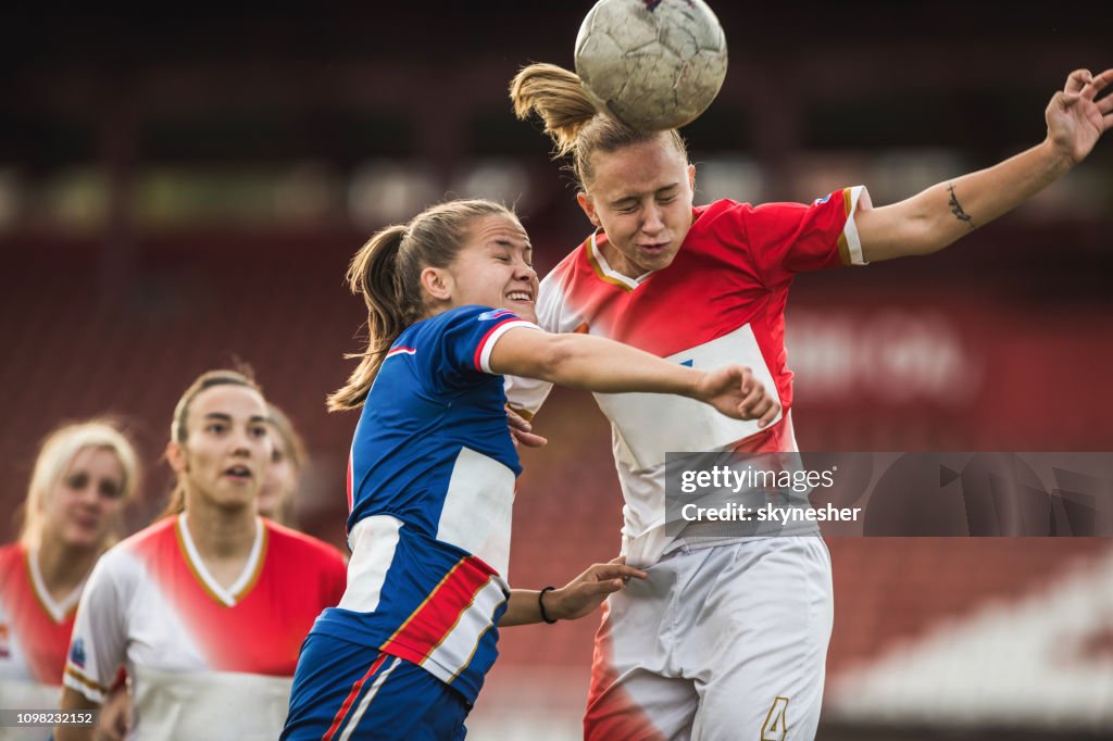 Zwei weibliche Fußball-Rivalen ein Match den Ball unterwegs.