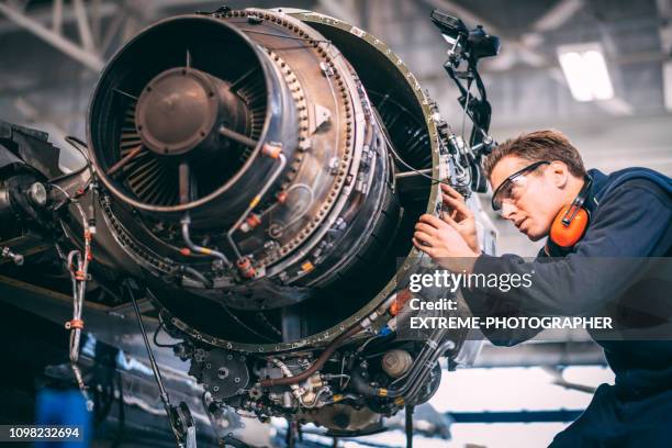 修復と小さな飛行機のジェット エンジンを維持する格納庫に航空機整備士 - aerospace engineer ストックフォトと画像