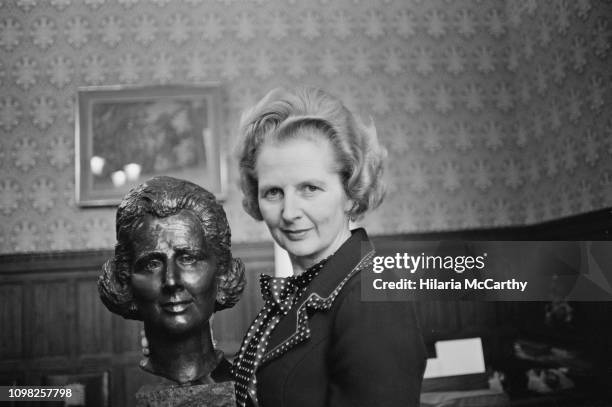 British Conservative Party politician and Leader of the Opposition Margaret Thatcher with her bronze bust by artist Beatrice Murray, UK, 13th...