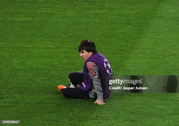 Lionel Messi of Barcelona sits on the pitch during a training session ahead of their UEFA Champions League round of 16 second leg match against...