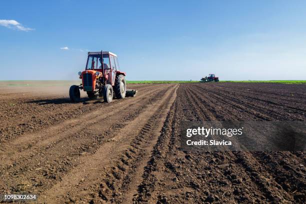 tractores en el campo agrícola la siembra en primavera - campo arado fotografías e imágenes de stock