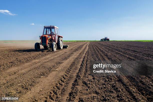 tractores en el campo agrícola la siembra en primavera - sembrar fotografías e imágenes de stock