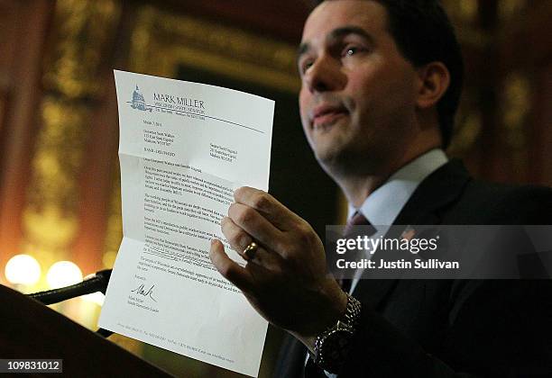 Wisconsin Gov. Scott Walker holds a letter from democratic State Sen. Mark Miller, one of the fourteen Wisconsin state senators who fled the state...