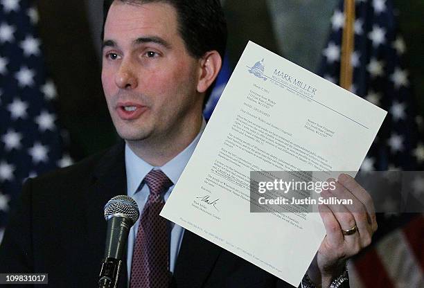 Wisconsin Gov. Scott Walker holds a letter from democratic State Sen. Mark Miller, one of the fourteen Wisconsin state senators who fled the state...