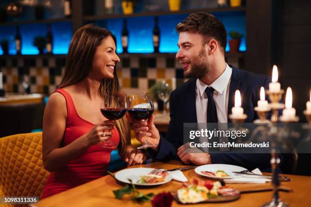 couple, appréciant le vin rouge le jour de la saint-valentin - diner en amoureux photos et images de collection