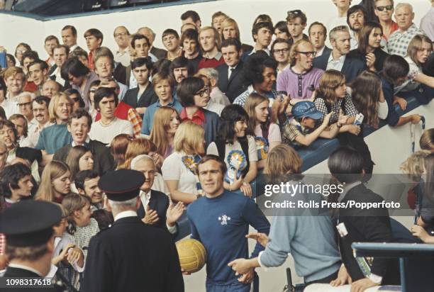 Chelsea supporters cheer as Chelsea defender Ron Harris leads the players out on to the pitch for a Football League Division One match at the club's...