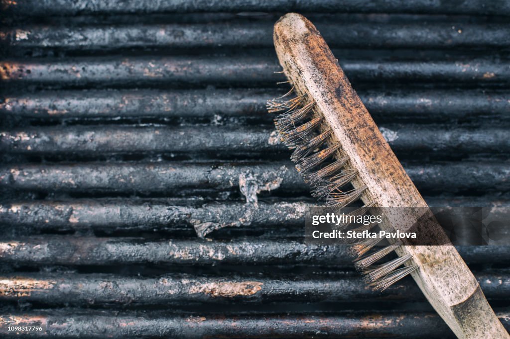Close-Up Of Dirty used Barbecue Grill and scrubber