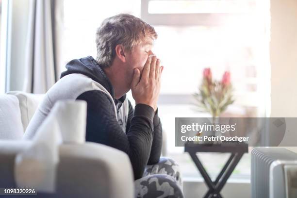 an adult male sick at home. - culpabilidad fotografías e imágenes de stock