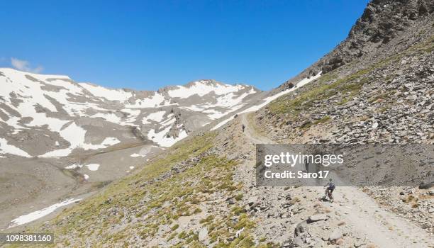 aerial view of mountainbikers high up at andalucian sierra nevada, spain. - andalucian sierra nevada stock pictures, royalty-free photos & images