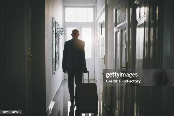 senior businessman leaving his hotel room - leaving stock pictures, royalty-free photos & images