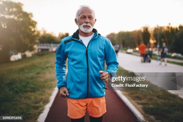 vital hombre mayor preparación para un maratón - chándal fotografías e imágenes de stock