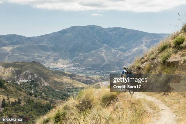 mountainbiking on narrow single trail at andalucian sierra nevada, spain. - andalucian sierra nevada stock pictures, royalty-free photos & images