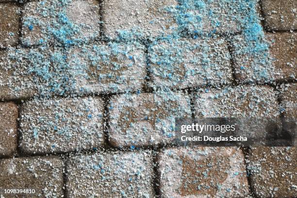 ice melt crystals on a paved sidewalk for snow removal - salz streuen stock-fotos und bilder