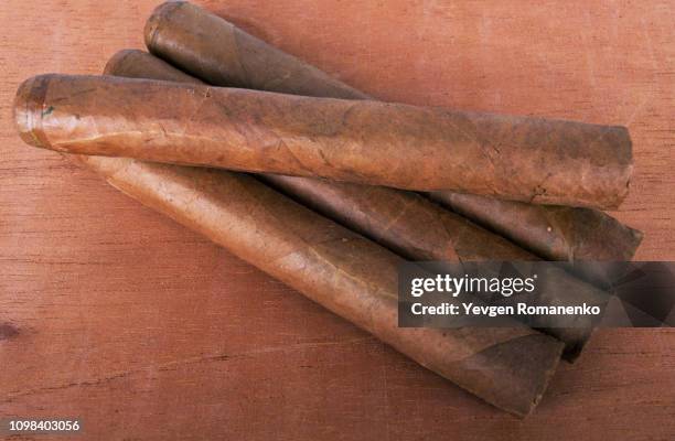 four cigars isolated on wooded background - cigar texture stock pictures, royalty-free photos & images