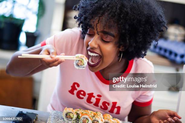 girl eating sushi - woman sushi stock-fotos und bilder