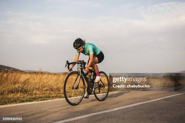 professional female cyclist on the road - racing bicycle stock pictures, royalty-free photos & images