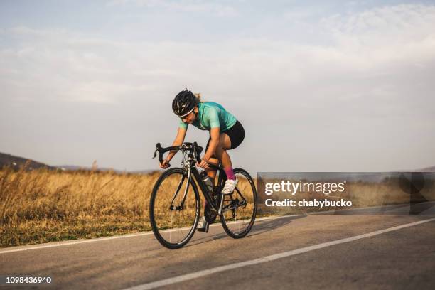 professional female cyclist on the road - bicicleta de corrida imagens e fotografias de stock