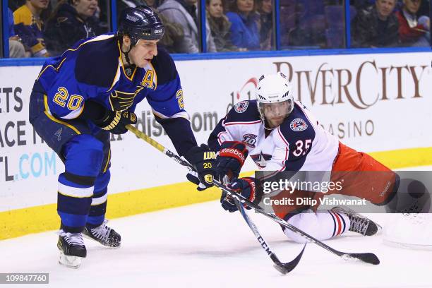 Alexander Steen of the St. Louis Blues and Jan Hejda of the Columbus Blue Jackets fight for control of the puck at the Scottrade Center on March 7,...