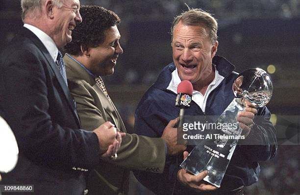 Super Bowl XXX: Dallas Cowboys coach Barry Switzer victorious holding Vince Lombardi Trophy with NBC Sports announcer Greg Gumbel and Cowboys owner...