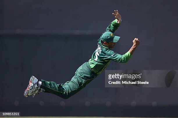 Younus Khan of Pakistan dives at first slip but fails to catch a chance from Jamie How during the New Zealand v Pakistan 2011 ICC World Cup Group A...