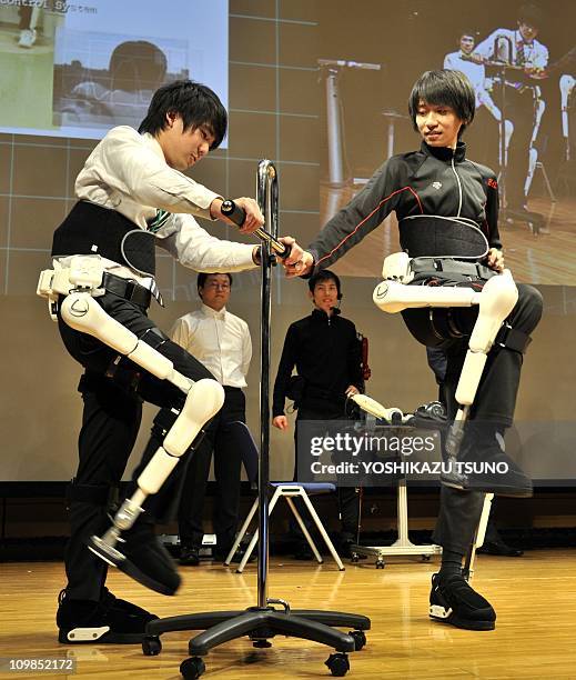 An employee of Japan's robot suit venture Cyberdyne demonstrates the new master-slave type HAL robotic exoskeleton which synchronizes the master's...