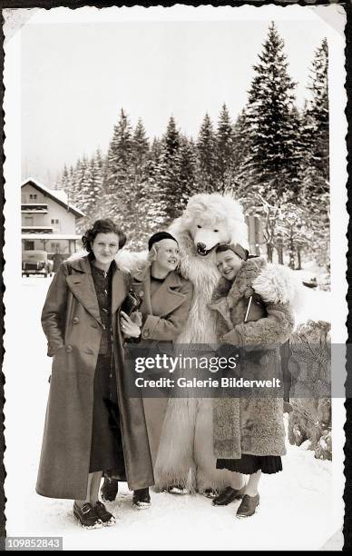 Eva Braun with two women and a person dressed as a polar bear in the Bavarian Alps, Germany, 1935.