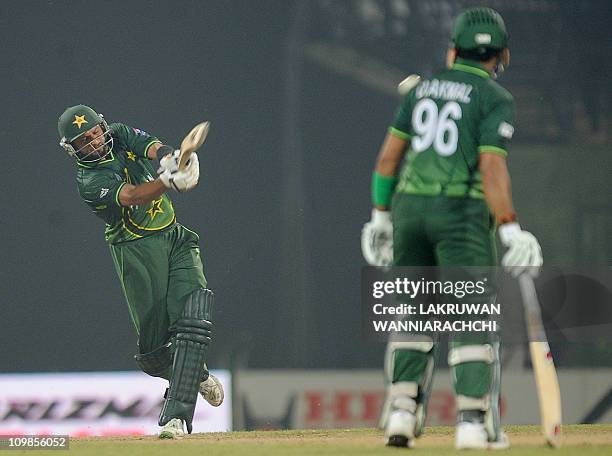 Pakistan cricket captain Shahid Afridi plays a shot as teammate Umar Akmal looks on during the Cricket World Cup Group A match between Pakistan and...