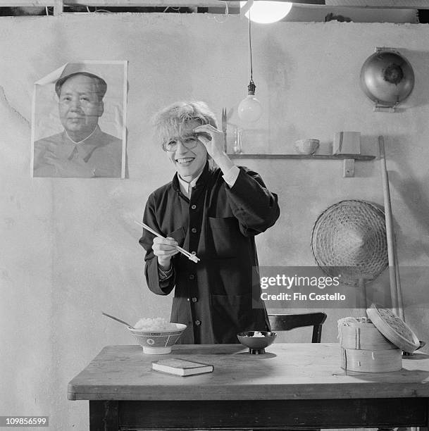 Posed portrait of David Sylvian from Japan holding chopsticks during the Tin Drum album photo session in November 1981. A poster of Chairman Mao...