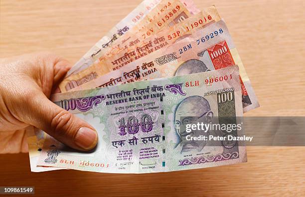 hand holding indian bank notes - indian currency stock pictures, royalty-free photos & images