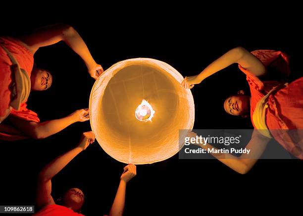 buddhist monks launching a khom loy lantern - sukhothai stockfoto's en -beelden