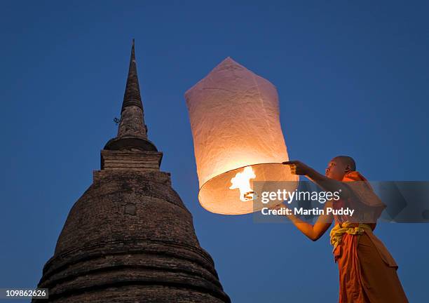 buddhist monk holding khom loy lantern - khom loy stock pictures, royalty-free photos & images