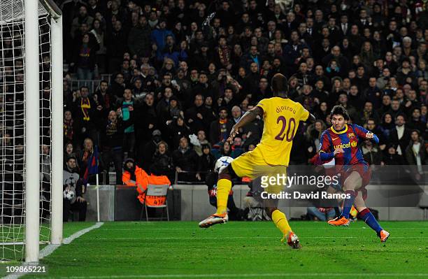 Lionel Messi of FC Barcelona scores his first team's side goal under a chanllenge by Johan Djourou of Arsenal during the UEFA Champions League round...
