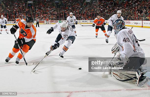 Goaltender Devan Dubnyk and Tom Gilbert of the Edmonton Oilers defend the loose puck from Kimmo Timonen of the Philadelphia Flyers on March 8, 2011...