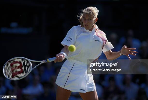 Steffi Graf of Germany plays a forehand return against Martina Hingis of Switzerland during their Women's Singles First Round match at the Wimbledon...