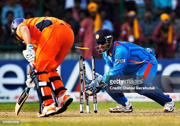 Captain MS Dhoni of India assists in the run out of Bradley Kruger of the Netherlands off the throw from Virat Kohli during the 2011 ICC Cricket...