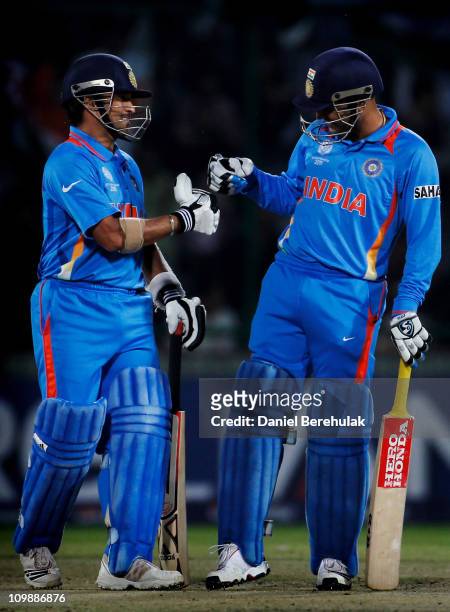 Sachin Tendulkar and Virender Sehwag of India bump fists during the 2011 ICC Cricket World Cup Group B match between India and the Netherlands at...