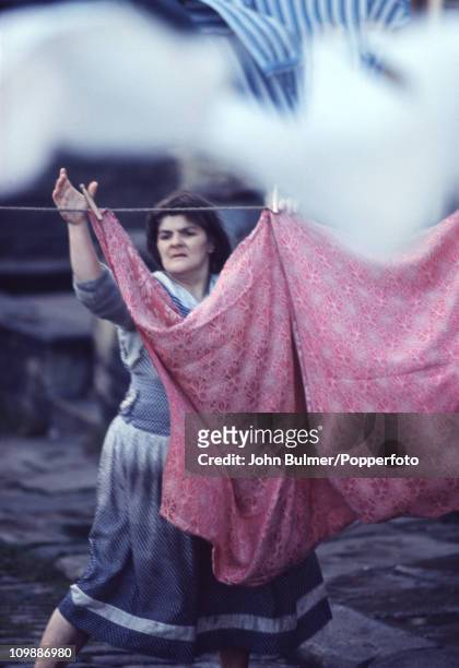 Woman hangs up her laundry on a street in Halifax, West Yorkshire in 1965.
