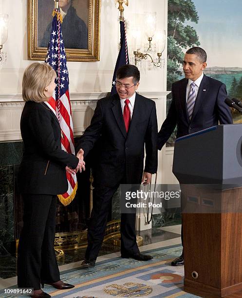 President Barack Obama looks on as Secretary of Commerce Gary Locke shakes hands with U.S. Secretary of State Hillary Clinton after announcing the...