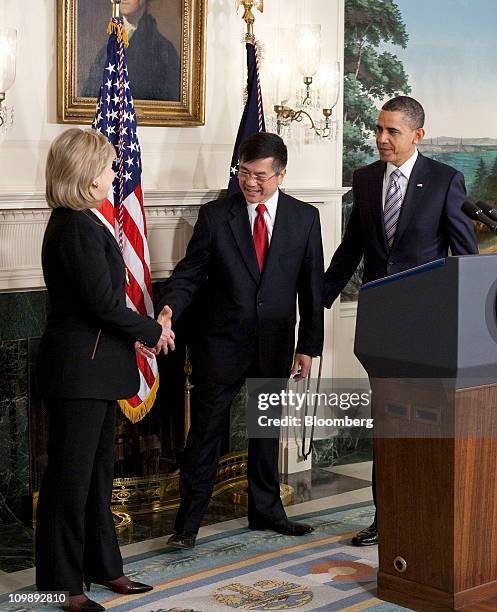 Gary Locke, U.S. Secretary of commerce, center, shakes hands with Hillary Clinton, secretary of state, after his nomination to be the next U.S....