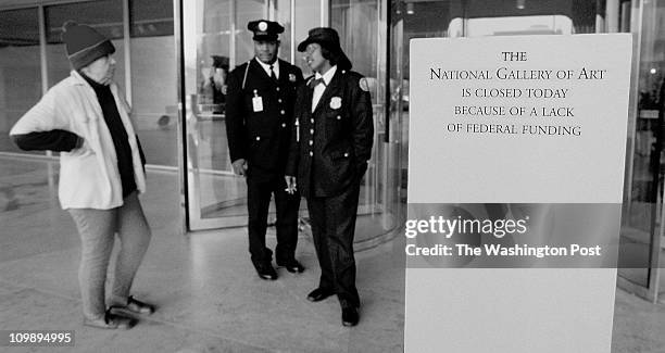 Security guards explain to a visitor that she will not be able to enter the National Gallery of Art because of the federal shutdown.