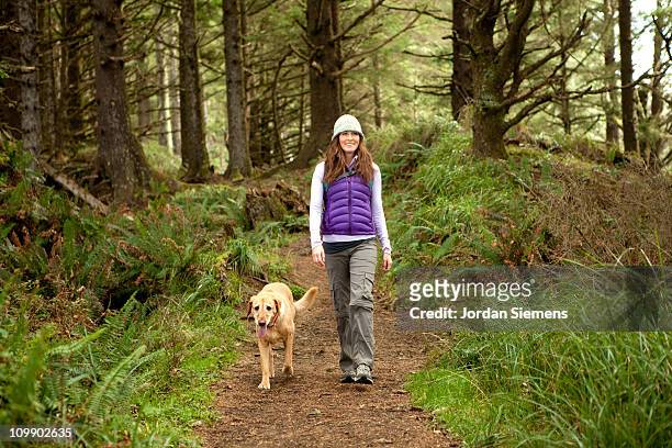 female hiking with her dog. - dog hiking stock pictures, royalty-free photos & images