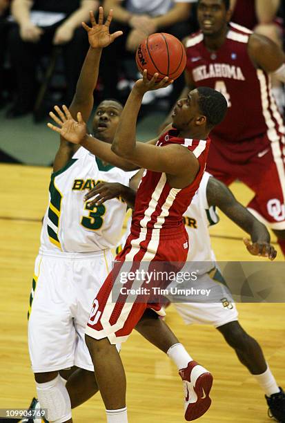 Steven Pledger of the Oklahoma Sooners goes up for a shot over Fred Ellis of the Baylor Bears during the first round of the 2011 Phillips 66 Big 12...