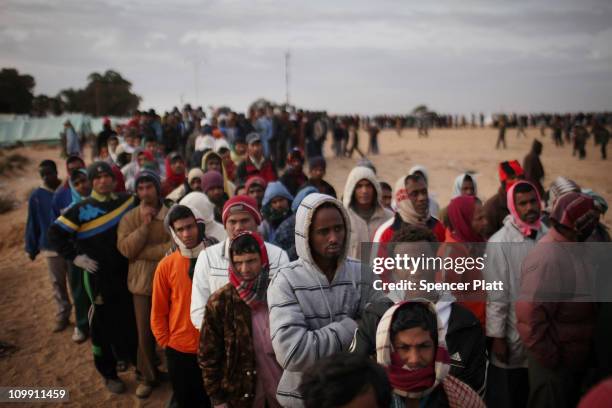 Men who recently crossed into Tunisia from Libya wait in line for food in a United Nations displacement camp on March 10, 2011 in Ras Jdir, Tunisia....