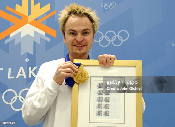 Steven Bradbury, one of Australia's two gold medalists, poses with his commemorative stamps and gold medal during the Australian press conference at...