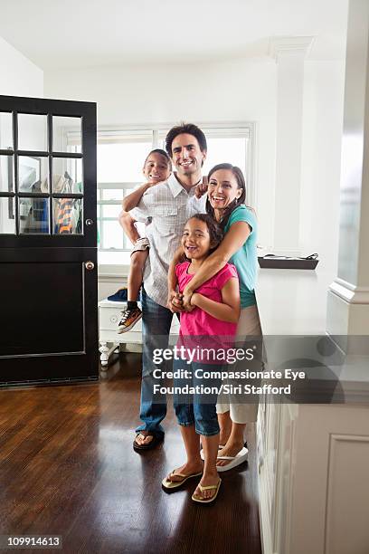 smiling family standing together in entryway - family 2010 stock pictures, royalty-free photos & images