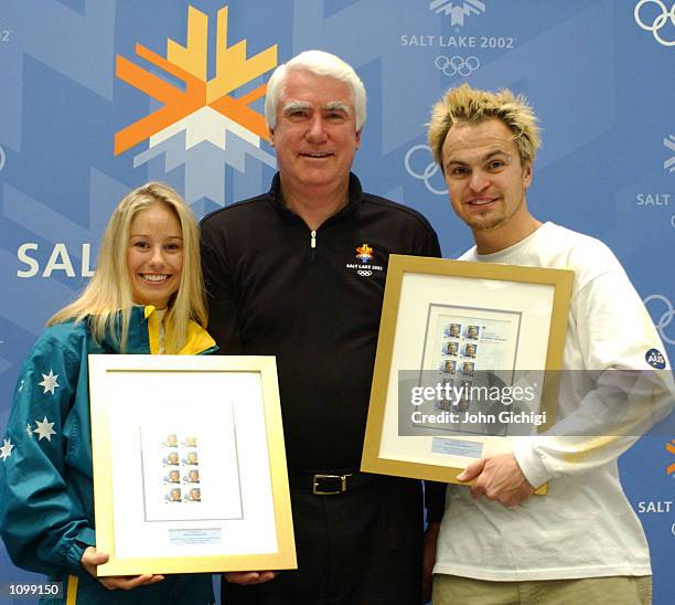 Graham John, CEO of Australia Post, presents Alisa Camplin and Steven Bradbury, Australia's two gold medalists, with their commemorative stamps...