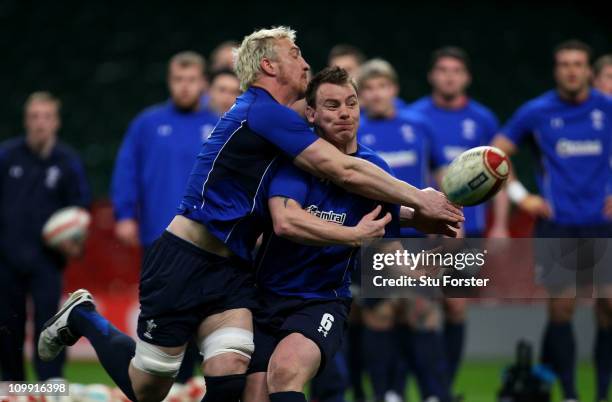 Wales captain Matthew Rees passes the ball despite the attentions of Andy Powell during Wales training at the Millennium Stadium on March 10, 2011 in...