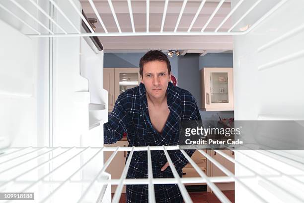 man looking into empty fridge - refrigerator stock-fotos und bilder