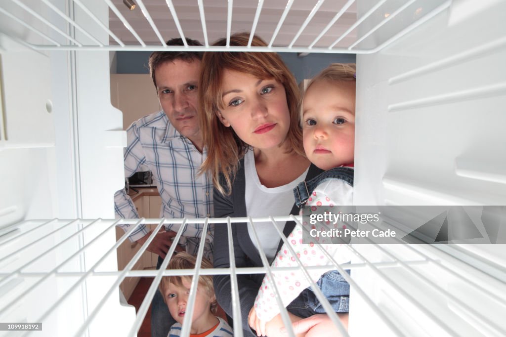 Family looking into empty fridge